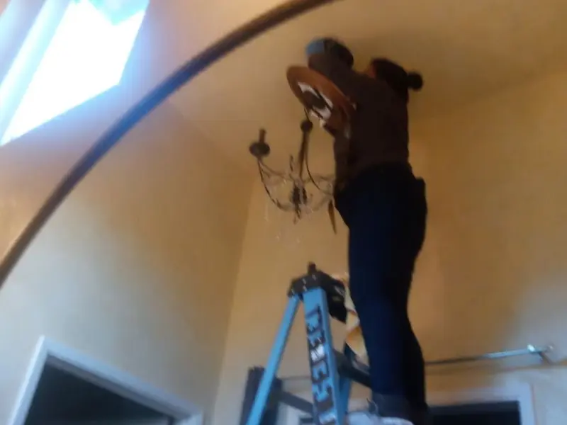 Electrician installing a chandelier in a Rocklin residence